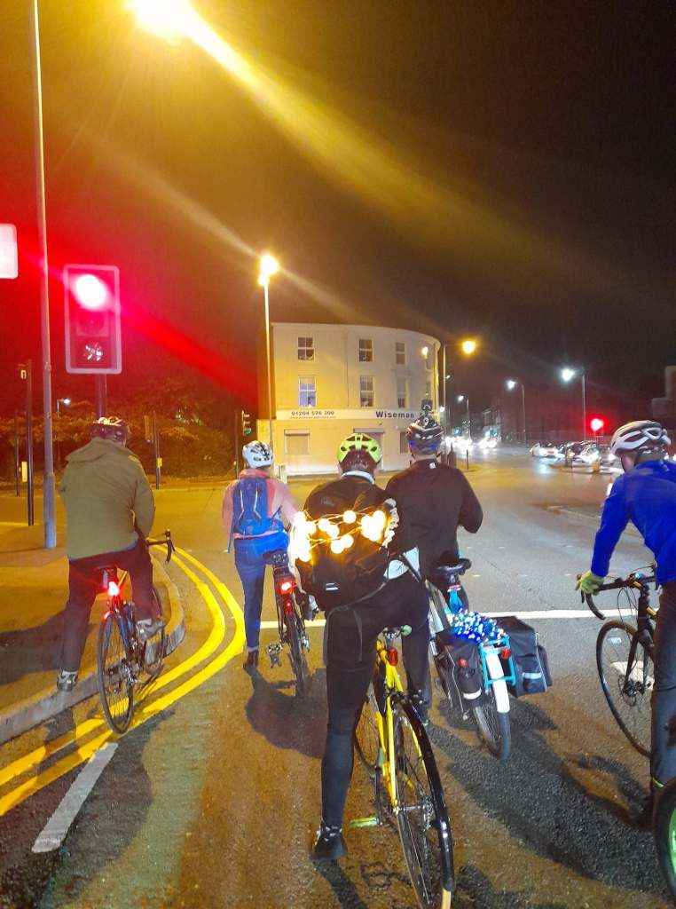 Cyclists in Halloween costumes waiting at a red traffic light. (Thanks to Sadie Tann)